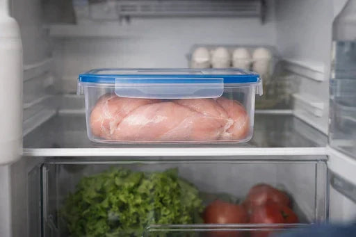 Raw chicken sealed in a container, safely stored in fridge