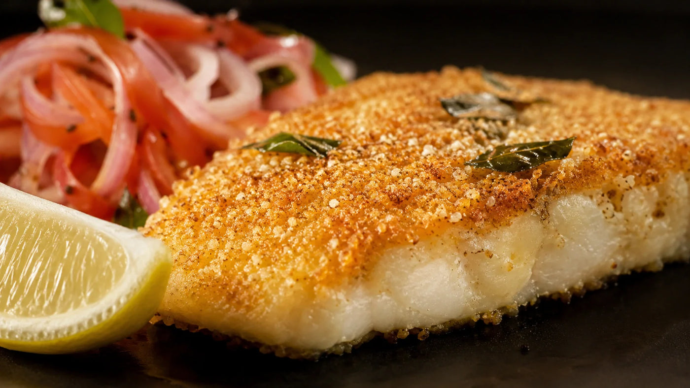 Fresh fish fillets prepared on a cutting board with lemon and herbs.